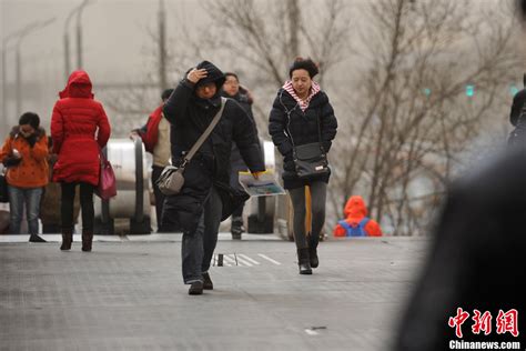 北京遭遇大风沙尘天气 街头行人秀发“清扬” 中新网