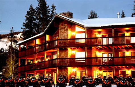 a large building with many motorcycles parked in front of it and snow on the ground