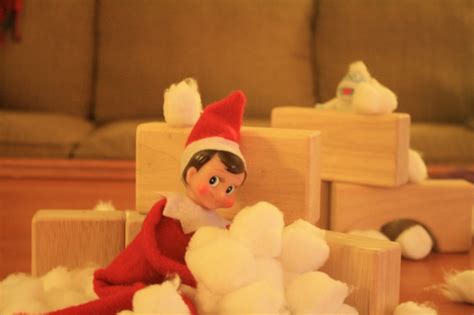 An Elf Is Sitting On The Floor Next To Cotton Balls