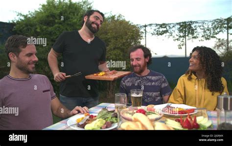 Group Of Cheerful Friends Eating Barbecue Together Bbq Chef Serving