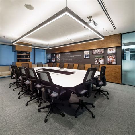 An Empty Conference Room With Black Chairs And White Table