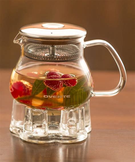 A Glass Tea Pot Filled With Water And Fruit