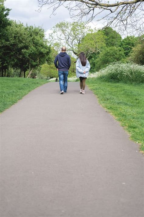 Foto Vertical De Una Pareja Multicultural Caminando Por Un Sendero En