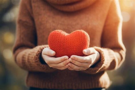 Premium Photo A Person Holding A Red Heart In Their Hands