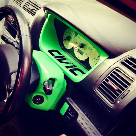 the interior of a car with green pedals and gauges