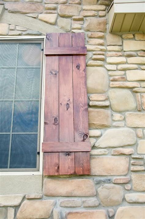 An Open Window On The Side Of A Stone Building With Wooden Shutters And