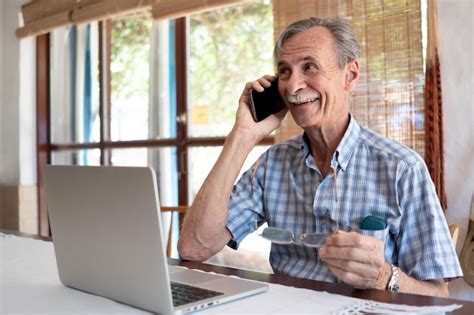 Premium Photo Mature Business Man Smiling And Talking On Phone In Front Of Laptop