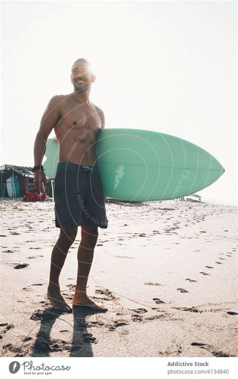 Fr Hlicher Surfer Mit Surfbrett Am Strand Stehend Ein Lizenzfreies