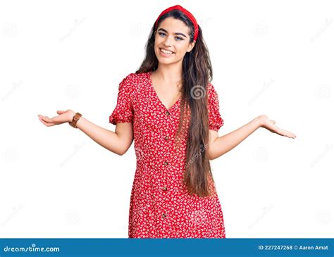 Una Adolescente De Brunette Con Vestido De Verano Sonriente Que Muestra Las Manos Abiertas
