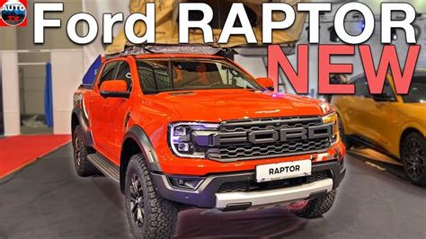 An Orange Ford Raptor Is On Display At The Auto Show