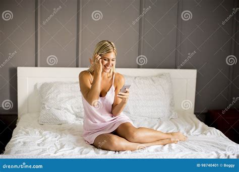 Mulher Que Usa O Telefone Celular Na Cama Imagem De Stock Imagem De