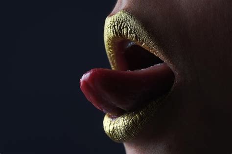 Lengua sensual lamer los labios lápiz labial de brillo dorado estilo de