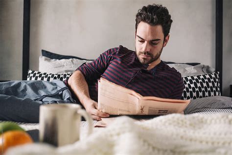 «Man Reading The Paper In Bed» del colaborador de Stocksy «Lumina ...