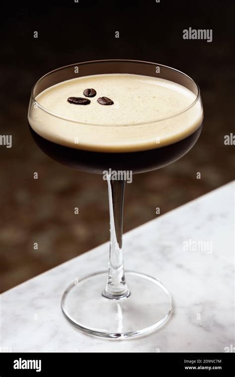 Espresso Martini Garnished With Three Coffee Beans On A Marble Table