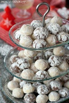 Three Tiered Trays Filled With Cookies And Powdered Donuts On A Table