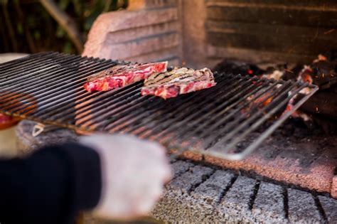 Um pessoa preparar grelhados carne ligado churrasco Foto Grátis