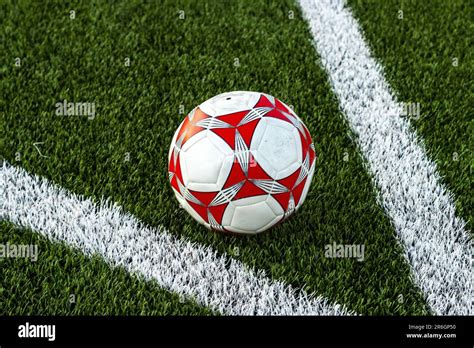 A Close Up Shot Of A Soccer Ball Resting On A Grass Field With White