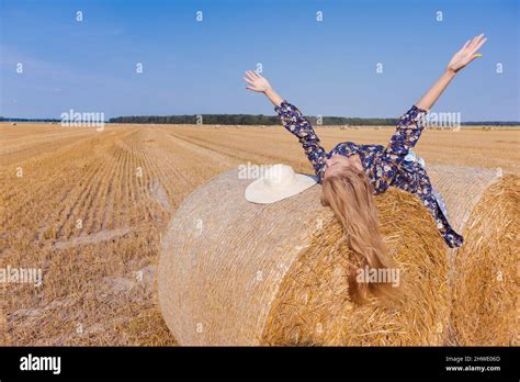 Une Jeune Fille Blonde Aux Cheveux Longs Dans Un Chapeau Blanc Se Repose Et Pose Pr S Des Gerbes
