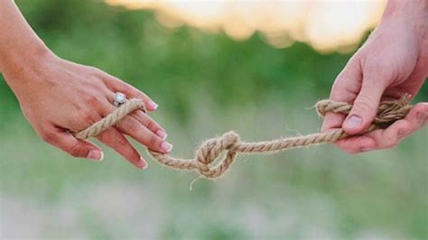 Two Hands Holding A Rope That Has Been Tied Together