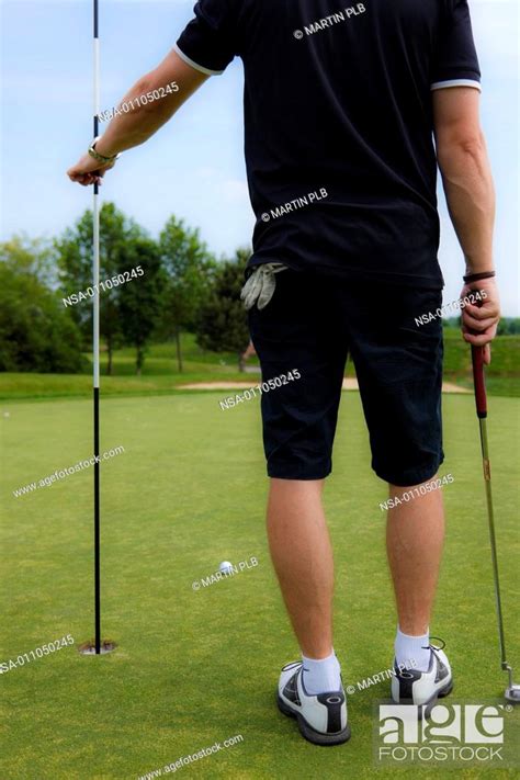 Man Holding Pin On Golf Course Stock Photo Picture And Rights Managed