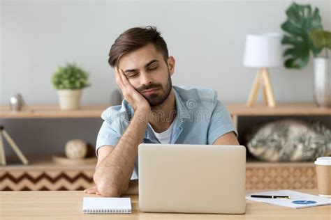 Exhausted Man Fall Asleep Near Laptop At Home Workplace Stock Image