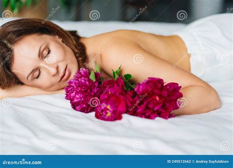 Gentle Brunette Topless Woman With A Bouquet Of Peonies On The Bed Stock Photo Image Of