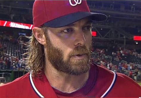 A Close Up Of A Baseball Player Wearing A Red Hat And Long Hair With A