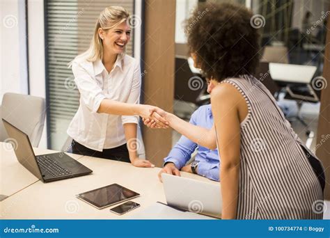 Welcoming Business Woman Giving A Handshake And Smiling Stock Photo