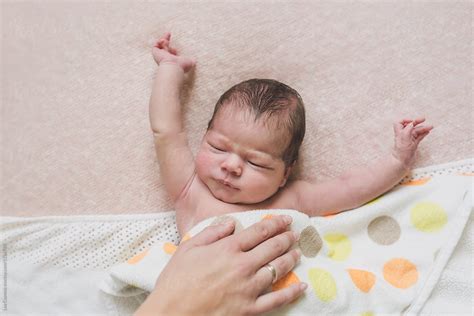 «Newborn Baby Stretching Under A Blanket With Her Mother's Hand On Her ...