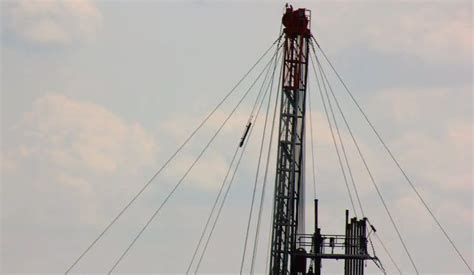 an airplane is flying over the top of a tower with wires attached to it's sides