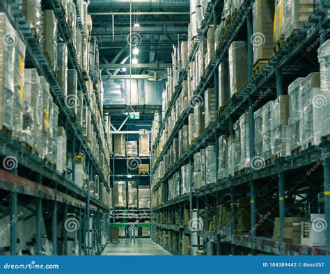 Rows Of Shelves With Boxes In Modern Large Scale Warehouse Stock Photo