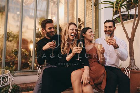 Couples Raising Their Champagne Glasses At A Retreat Jacob Lund