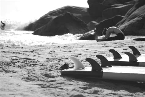 Grayscale Photo Of Woman Sitting On Beach Near Rock Kwentong Dagat