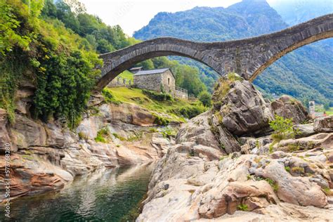 Ancient double arch stone Roman bridge (Ponte dei Salti) over the clear ...