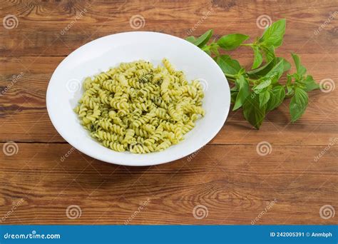 Spiral Pasta With Sauce Pesto On Dish Against Fresh Basil Stock Image