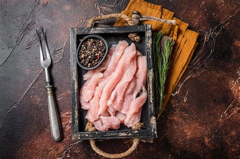 Rebanadas De Carne De Pollo Cruda Sin Cocer En Una Bandeja De Madera