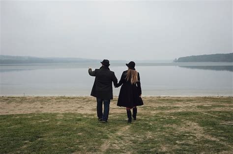 Joven pareja romántica acercándose a una vista del lago mientras están