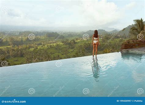 Beautiful Girl In Bikini In Infinity Pool Full Length Portrait Side