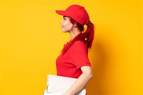 Premium Photo Pizza Delivery Girl Holding A Pizza Over Isolated Background In Lateral Position