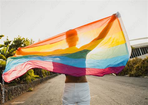 man Non binary unrecognizable walking by the street holding lgbt ...