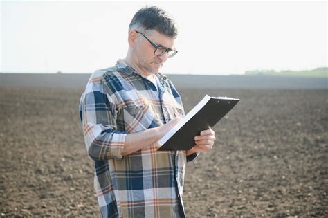 Premium Photo An Elderly Farmer In A Plowed Field Agriculture Crop