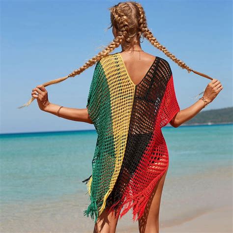 A Woman In A Colorful Crochet Cover Up Standing On The Beach With Her