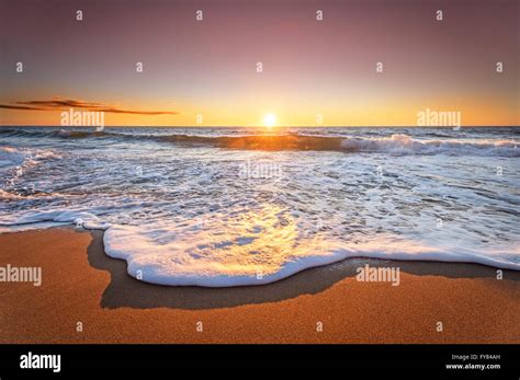 Colorful Ocean Beach Sunrise With Deep Blue Sky And Sun Rays Stock