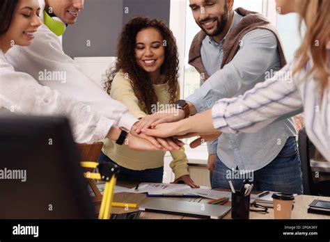 Team Of Employees Putting Hands Together In Office Startup Project