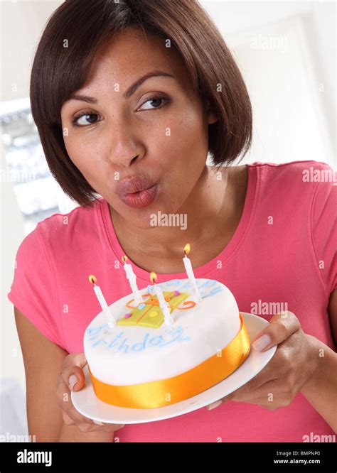 Woman Blowing Out Candles On Cake Photo Stock Alamy