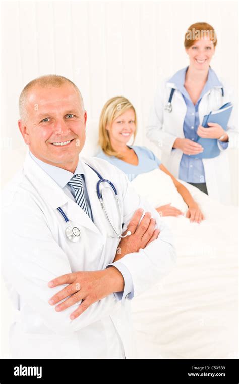 Two Medical Doctors Professional With Hospital Patient Lying In Bed