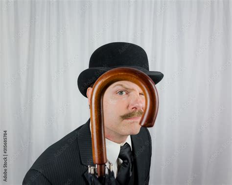 Portrait Of British Gentleman In Dark Suit And Bowler Hat Peering