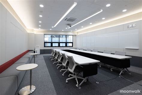 An Empty Conference Room With Long Tables And Chairs