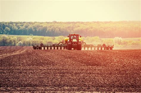 Premium Photo Tractor Plowing Farm Field In Preparation For Spring