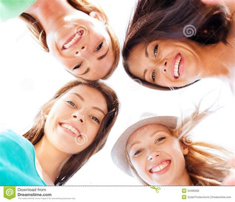 Caras Das Meninas Que Olham Para Baixo E Que Sorriem Foto De Stock